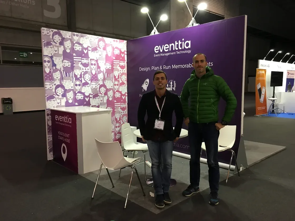 Mauricio et Esteban sur le stand Eventtia à IBTM World 2017 à Barcelone, devant un fond violet eventtia « Design, Plan & Run Memorable Events ».