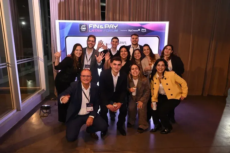 Photo de groupe d'environ onze personnes posant avec énergie devant un fond « FIN & PAY LATAM FORUM » au Fin & Pay Latam Forum 2026 de CMS People à Buenos Aires, sponsorisé par BigCheese et AWS.