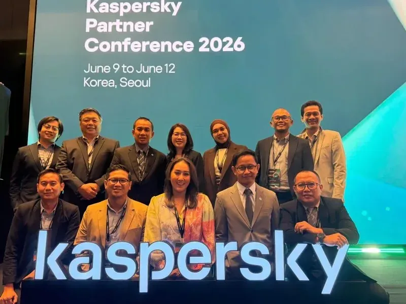 Photo de groupe d'une douzaine de personnes en tenue professionnelle à la Kaspersky Partner Conference 2026 à Séoul, devant une enseigne lumineuse géante « kaspersky ».