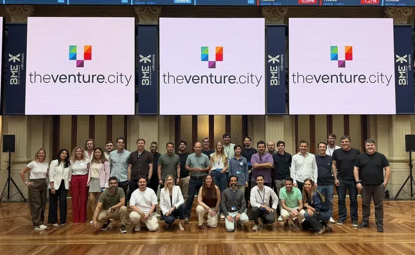Photo de groupe des participants sur scène au TheVentureCity Summit 2026 à la Bourse de Madrid, avec trois grands écrans theventure.city derrière eux.
