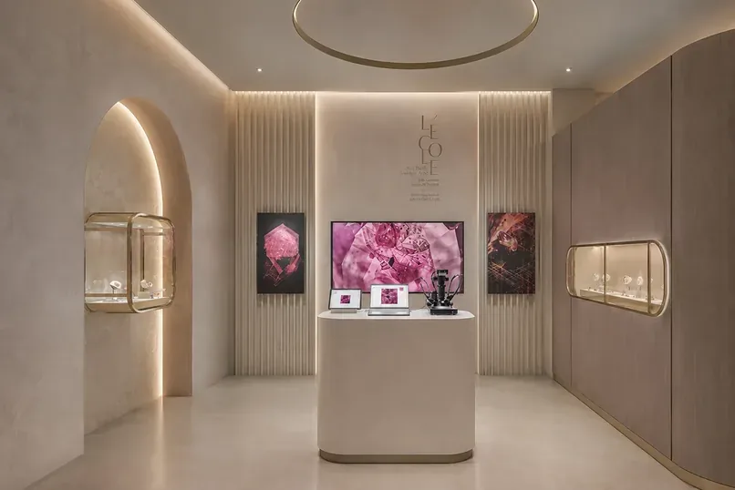 Intérieur de l'exposition « Ruby, Discover the Gemstones » de L'&Eacute;cole des Arts Joailliers de Van Cleef & Arpels à Singapour, avec une alcôve en arche, un piédestal central et une œuvre en cristal de rubis au fond.
