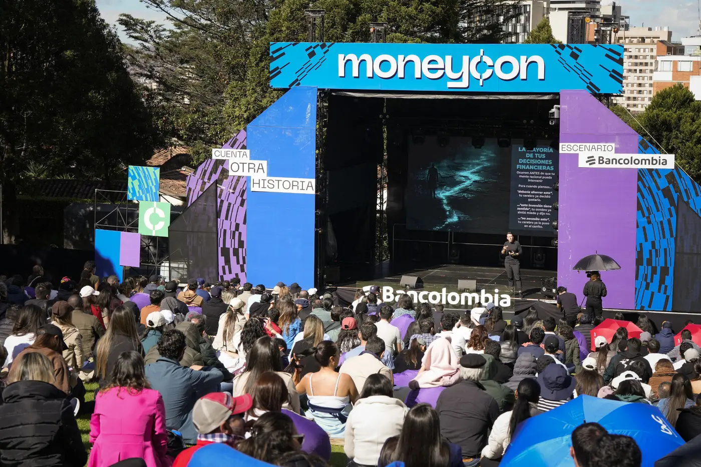 Una conferencia masiva al aire libre en Bogotá con el público sentado frente al escenario principal